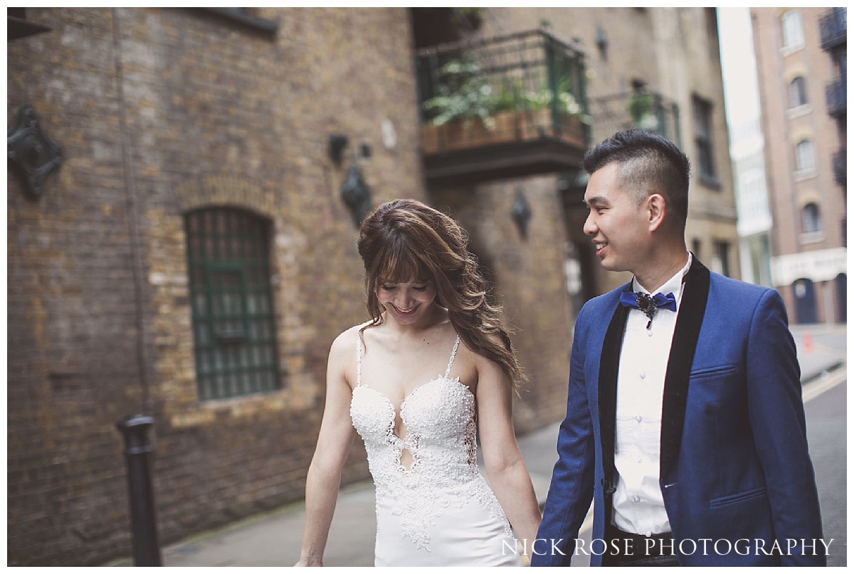 Couple walking along Shad Thames and holding hands for their Shad Thames pre wedding photo shoot in London