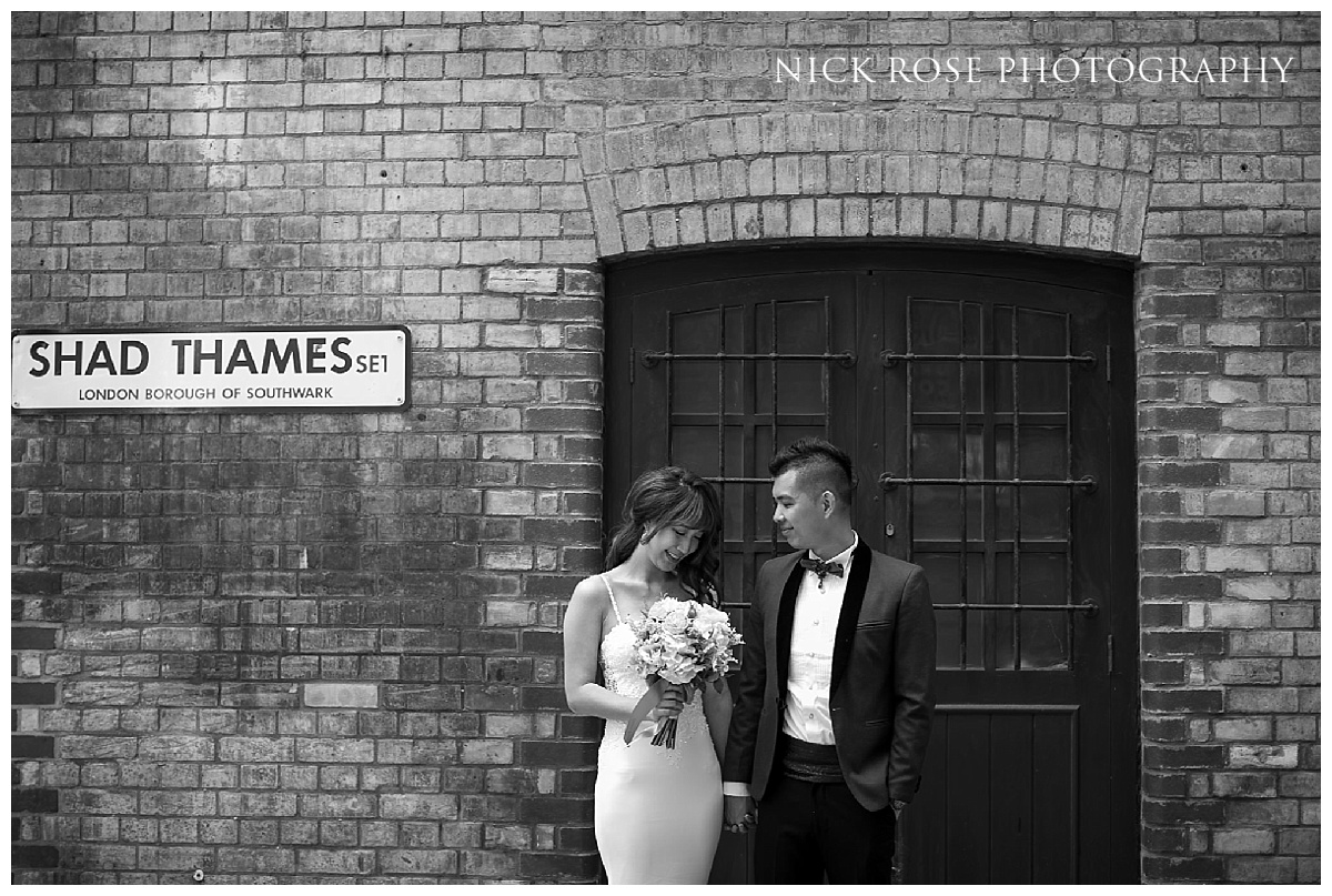Pre wedding couple standing in front of a warehouse doorway at Shad Thames in London