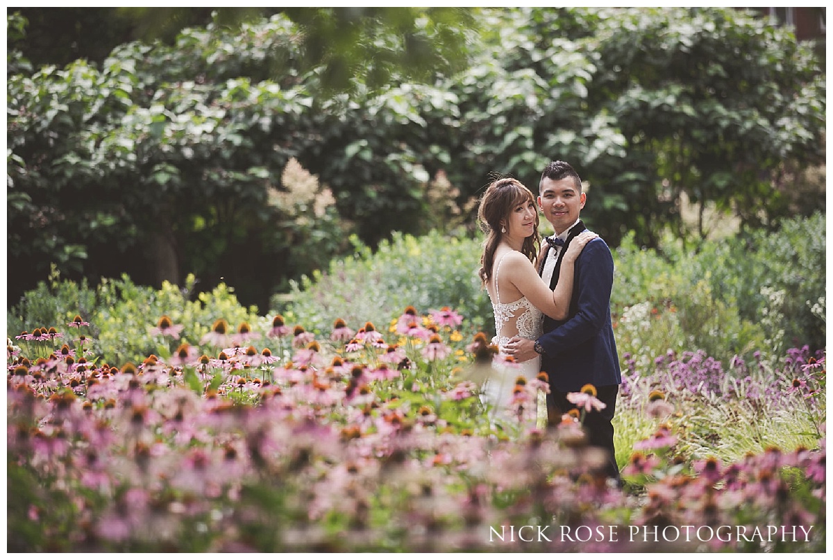  Pre wedding couple standing amongst flowers in Potter's Fields next to Tower Bridge in London 