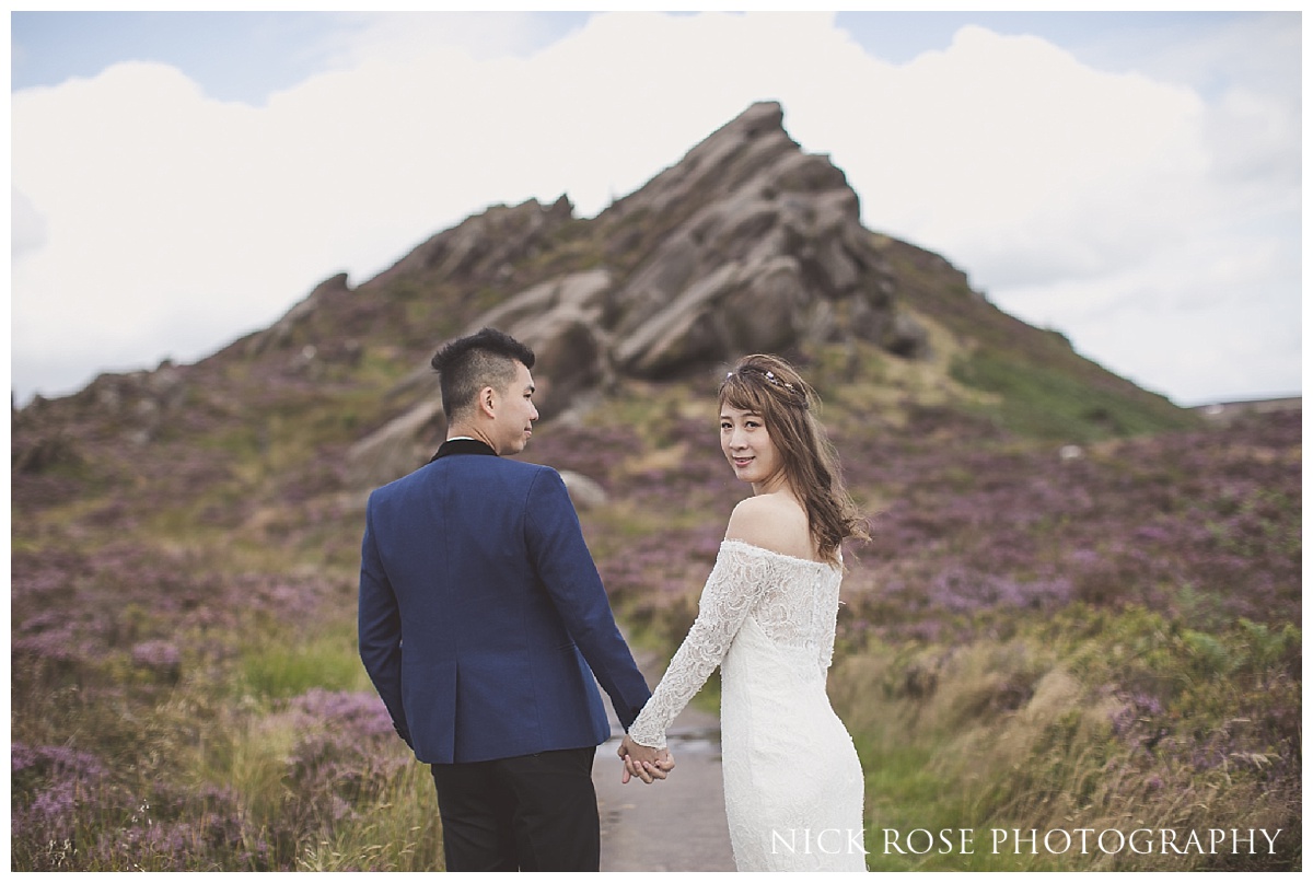  Pre wedding couple holding hands for a photograph at Ramshaw Rocks in the Peak District, Derbyshire 