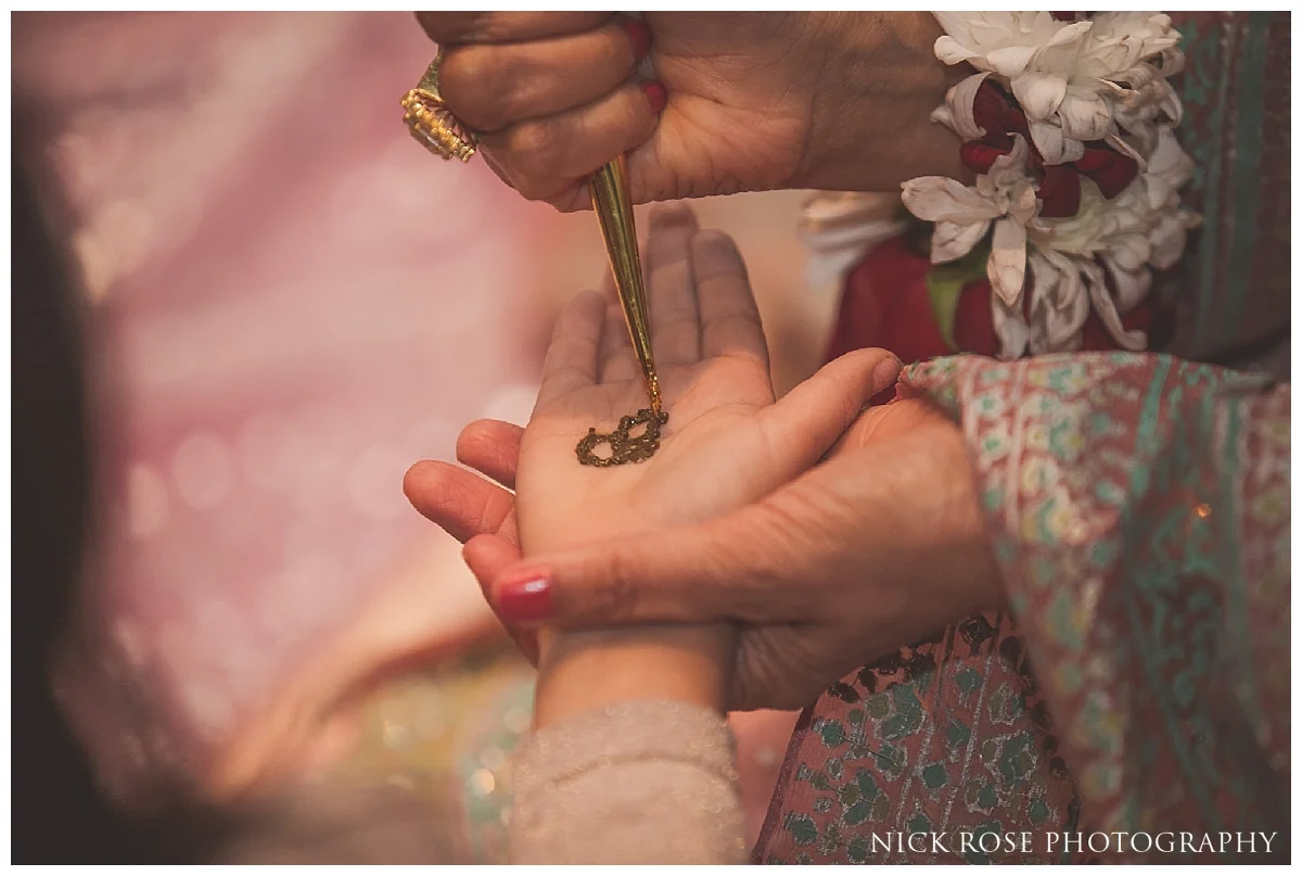 Henna being put on guests hands during a Pakistani wedding event at the Sheraton Grand in Park Lane