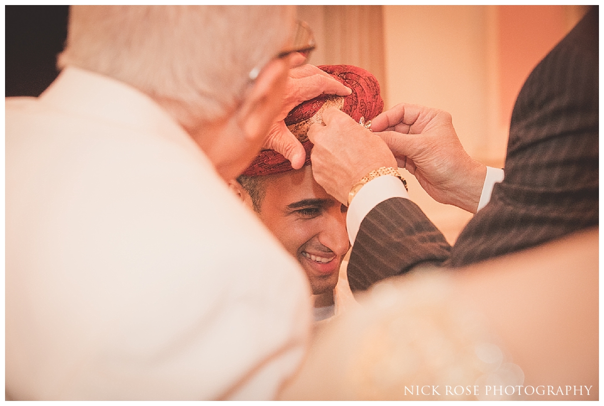  Pakistani groom having his turban tied before a South Asian wedding at the London Ritz Hotel in Piccadilly 