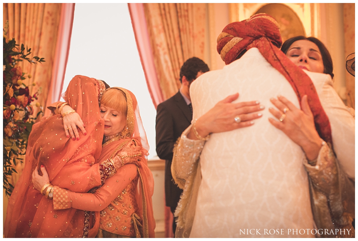  Parents hugging bride and groom following an Asian wedding ceremony at the Ritz in London 