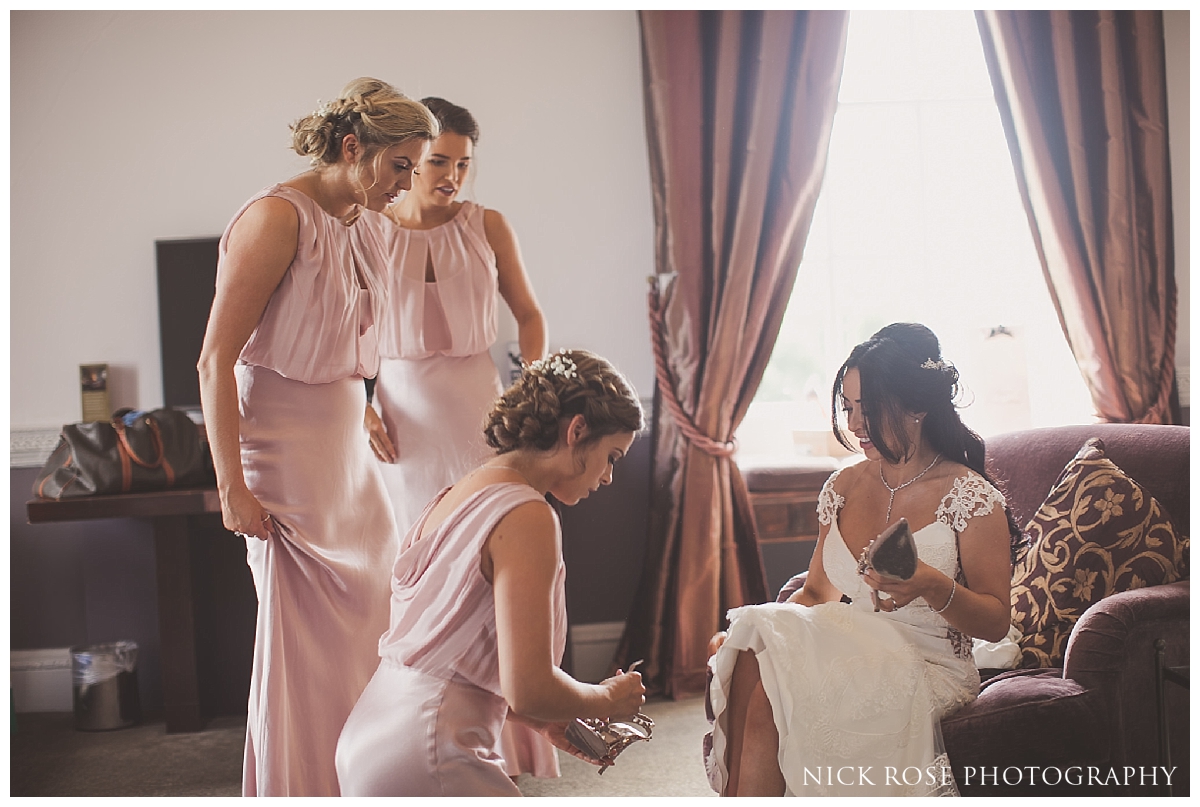  Bridesmaids helping bride get ready for a Buxted Park hotel wedding in East Sussex 