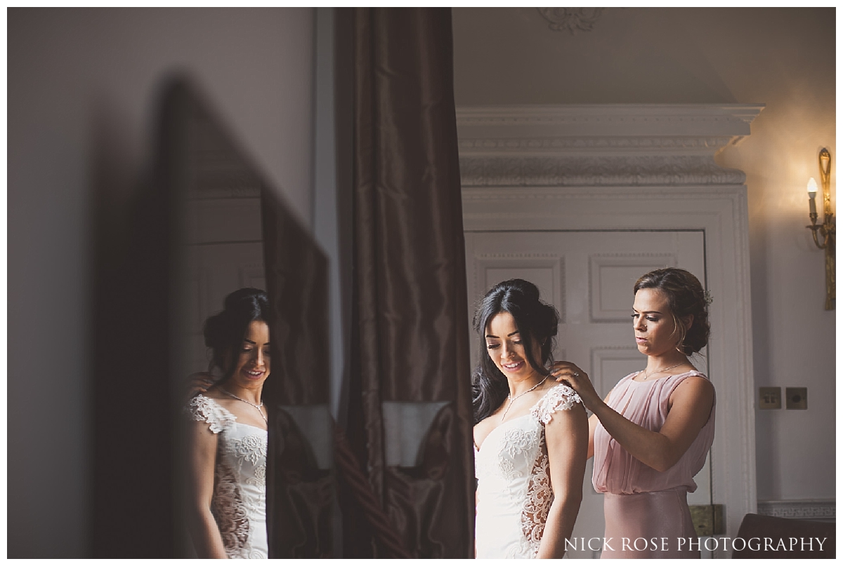 Bride putting on dress for a Buxted Park hotel wedding in East Sussex