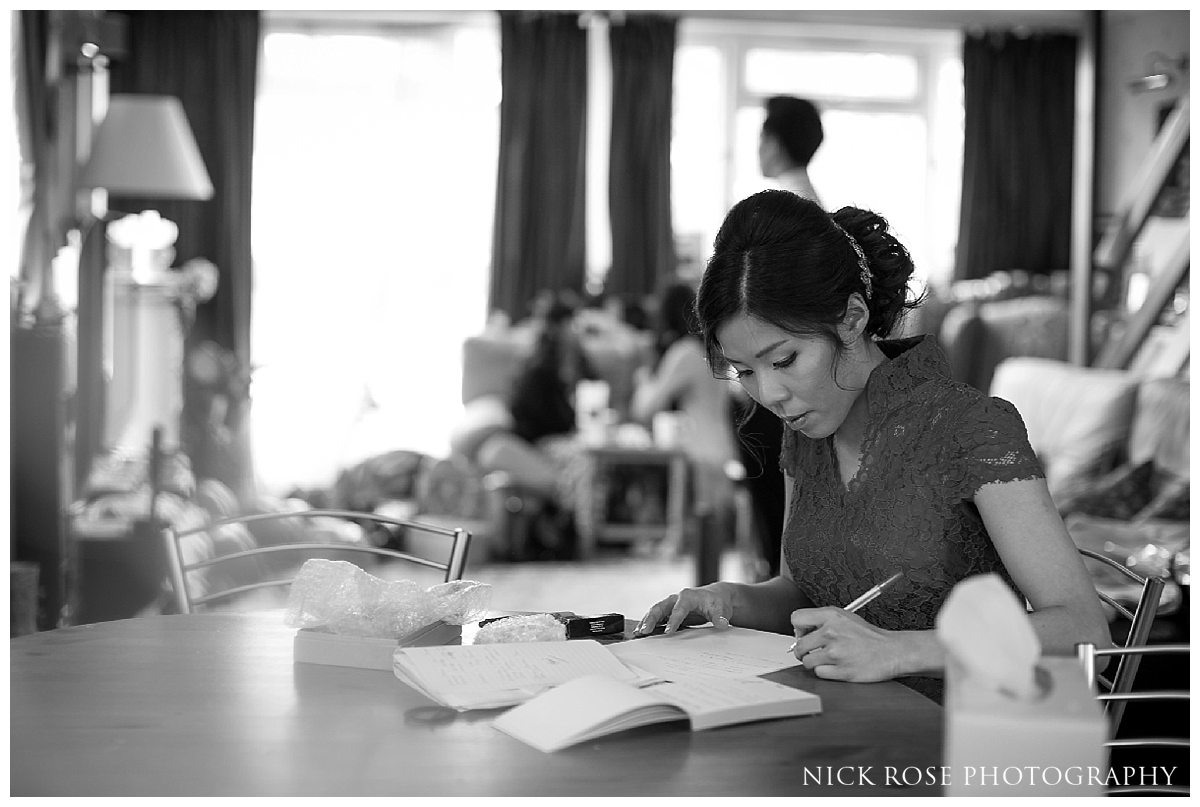  Bride writing her vows before a Hampton Court Place wedding at the Little Banqueting House in Surrey 