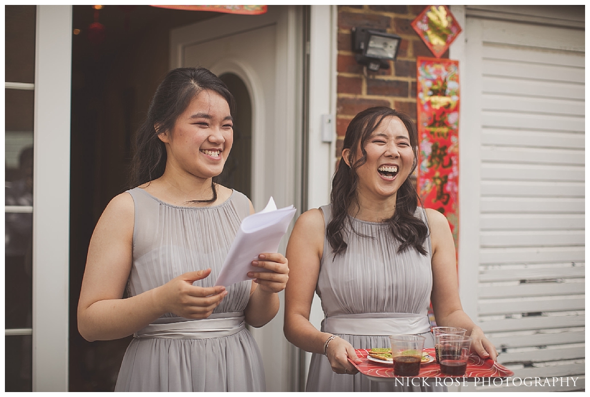  Asian bridesmaids reacting to gatecrashing games before a Hampton Court Place wedding at the Little Banqueting House in Surrey 