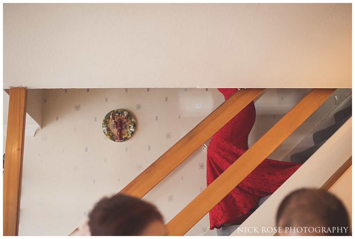  Bride in red wedding dress walking down stairs before her London wedding 