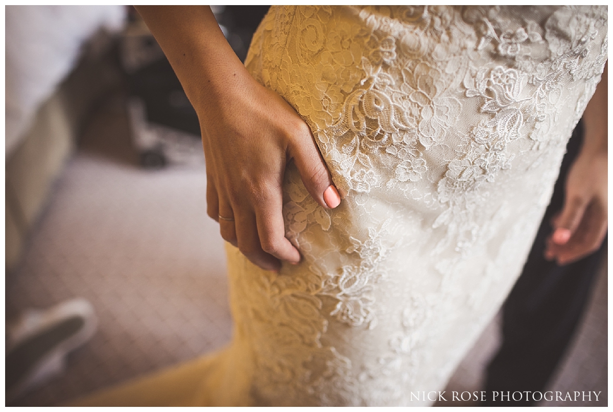  Bride putting on wedding dress for a central London wedding at Dartmouth House in Mayfair 