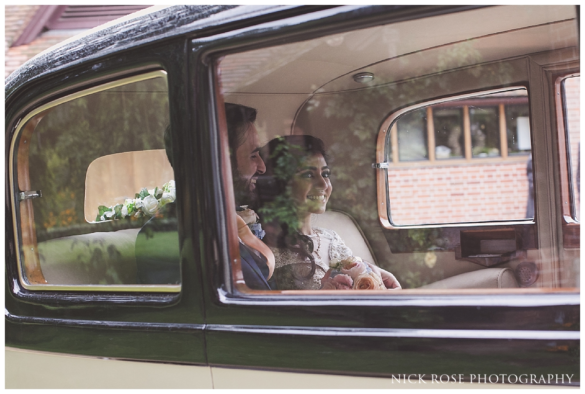  Bride and groom vintage car wedding exit from Waddesdon Manor in Buckinghamshire 