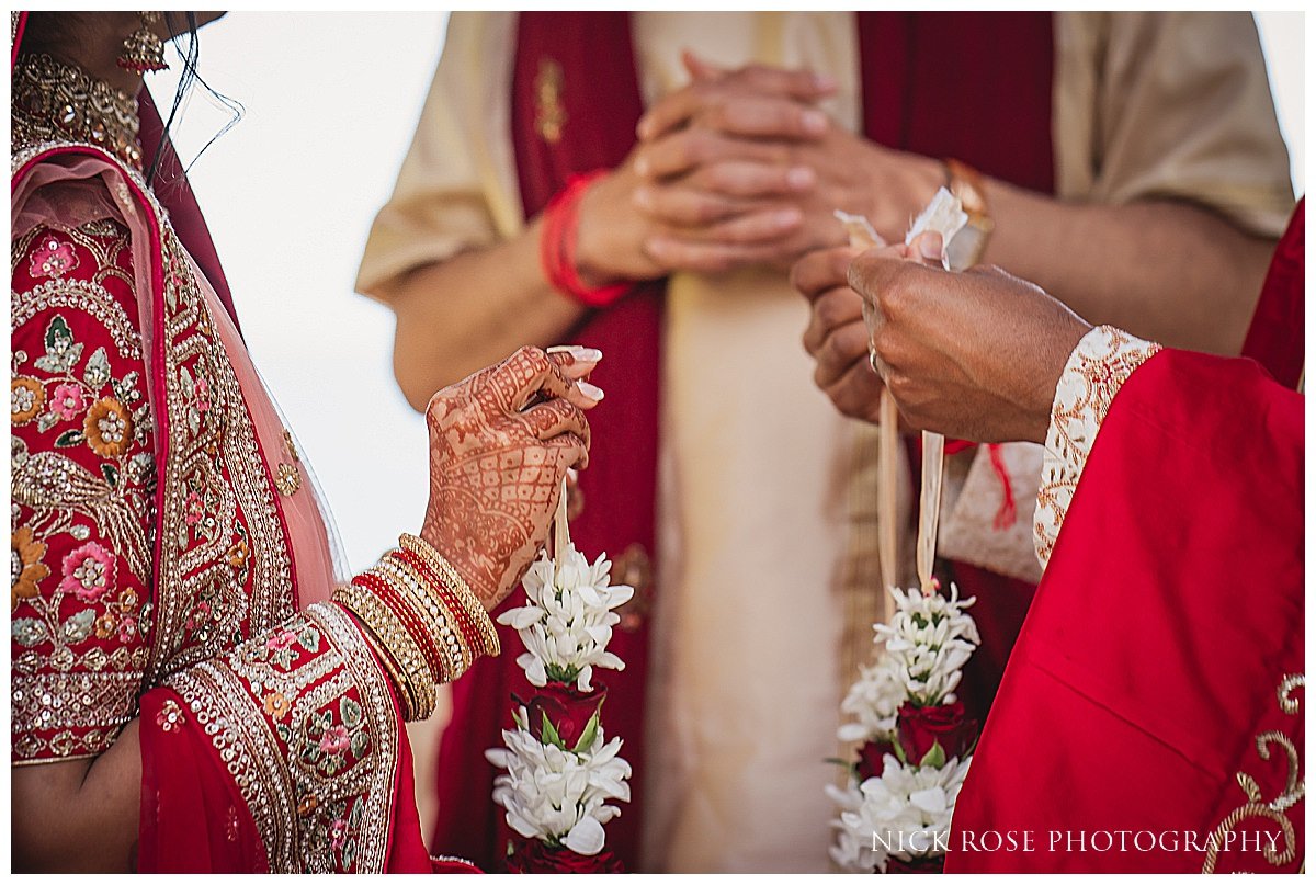 A candid moment of the bride and groom exchanging garlands, captured by destination Indian wedding photography at Pine Cliffs Resort in Portugal 