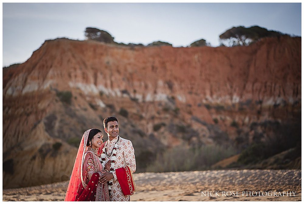  A romantic image of the couple posing against the beautiful backdrop of Pine Cliffs Resort for a destination Indian wedding 