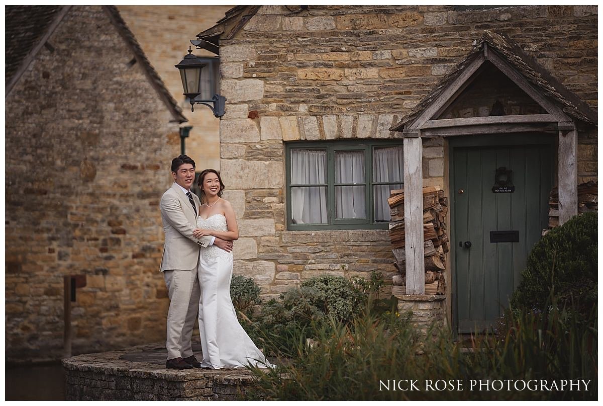  Future newlyweds sharing a quiet moment on a bench overlooking the tranquil waters of a Cotswold village stream 