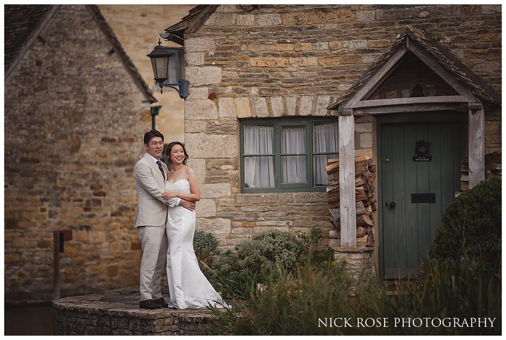  Future newlyweds sharing a quiet moment on a bench overlooking the tranquil waters of a Cotswold village stream 