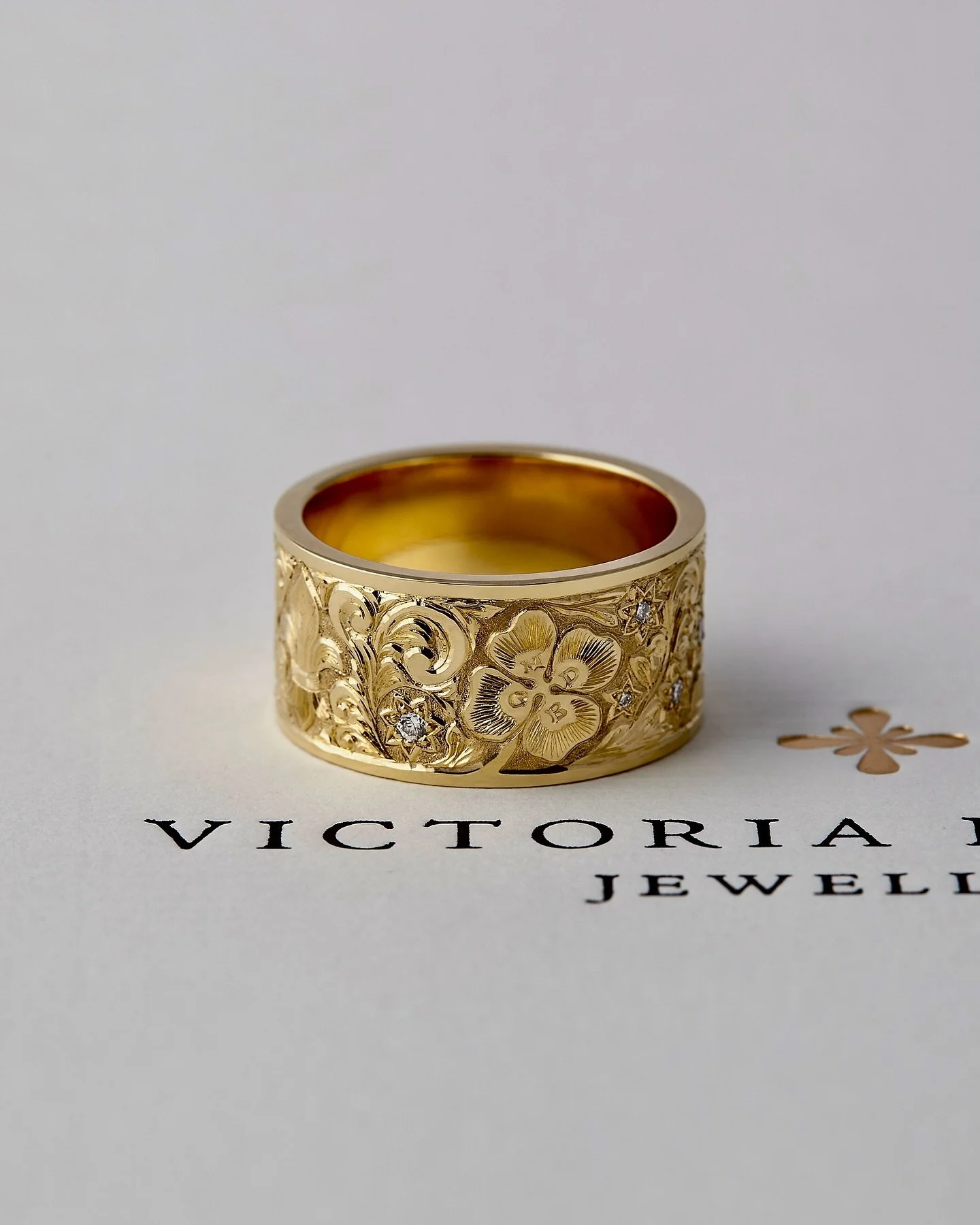 My lovely client flew in to commission this very personal ring , incorporating special memories of his most treasured locations over the years . 
A fleur de lis for France , a silver fern for NZ. The Irish shamrock has 1mm high letters representing l