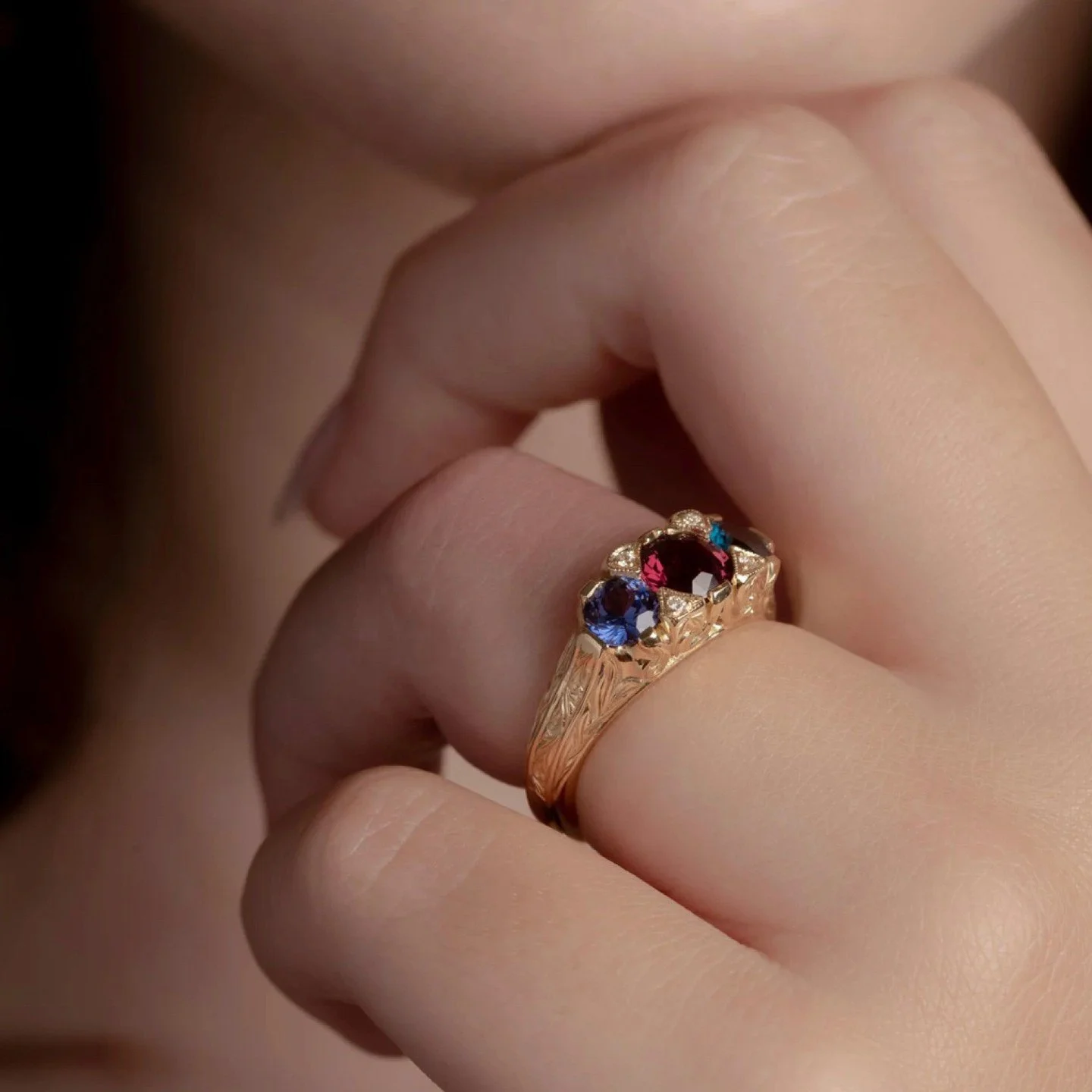 This is my modern take on a Victorian Bridge ring , with much deeper carving and a more solid structure than the antique variants remaining today .  Diamond set claws highlight the deeply carved woodland foliage and leaf engraved band . 

The colours