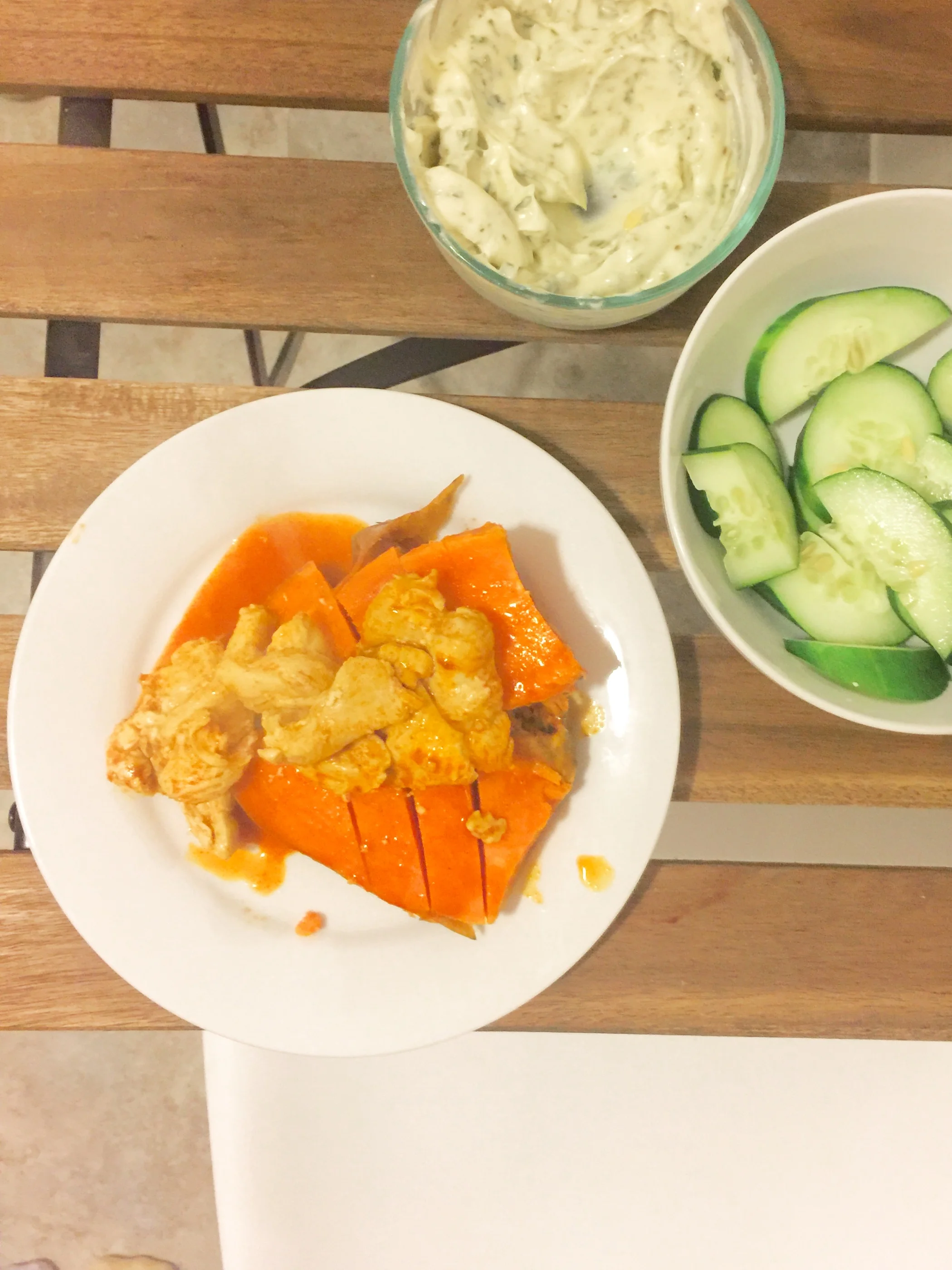 Buffalo chicken on a sweet potato with cucumbers and ranch