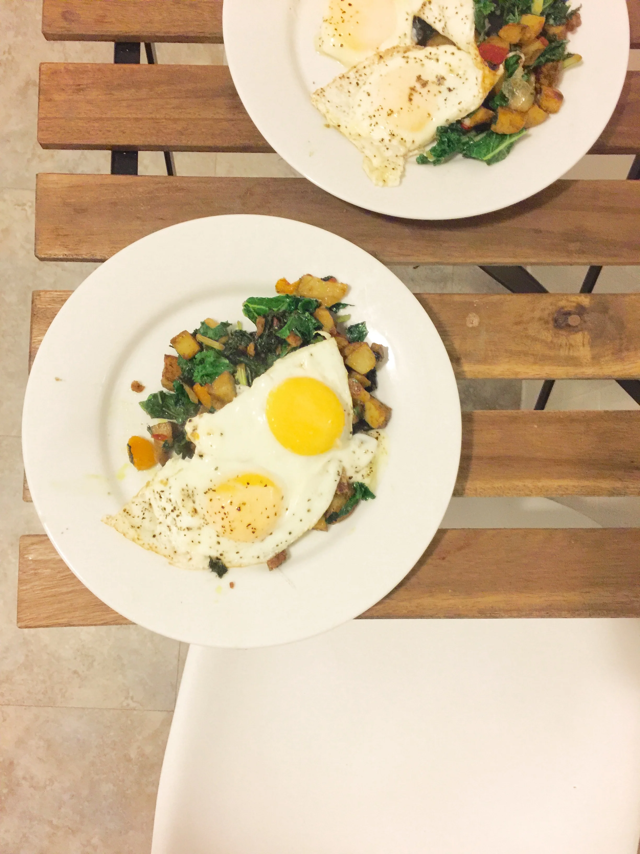 Peppers, curry potatoes, kale and butternut squash hash topped with two eggs 