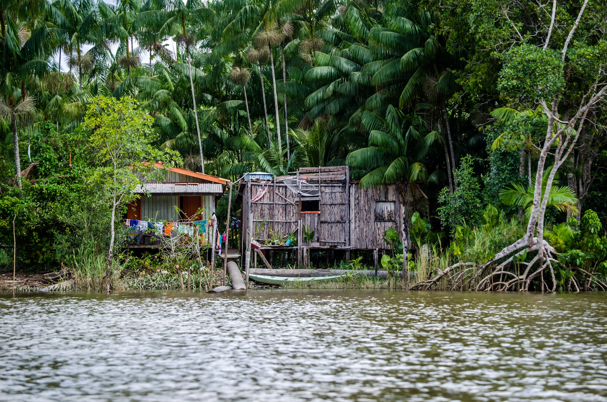 Typical river homes. Stilts, clotheslines, and canoes.