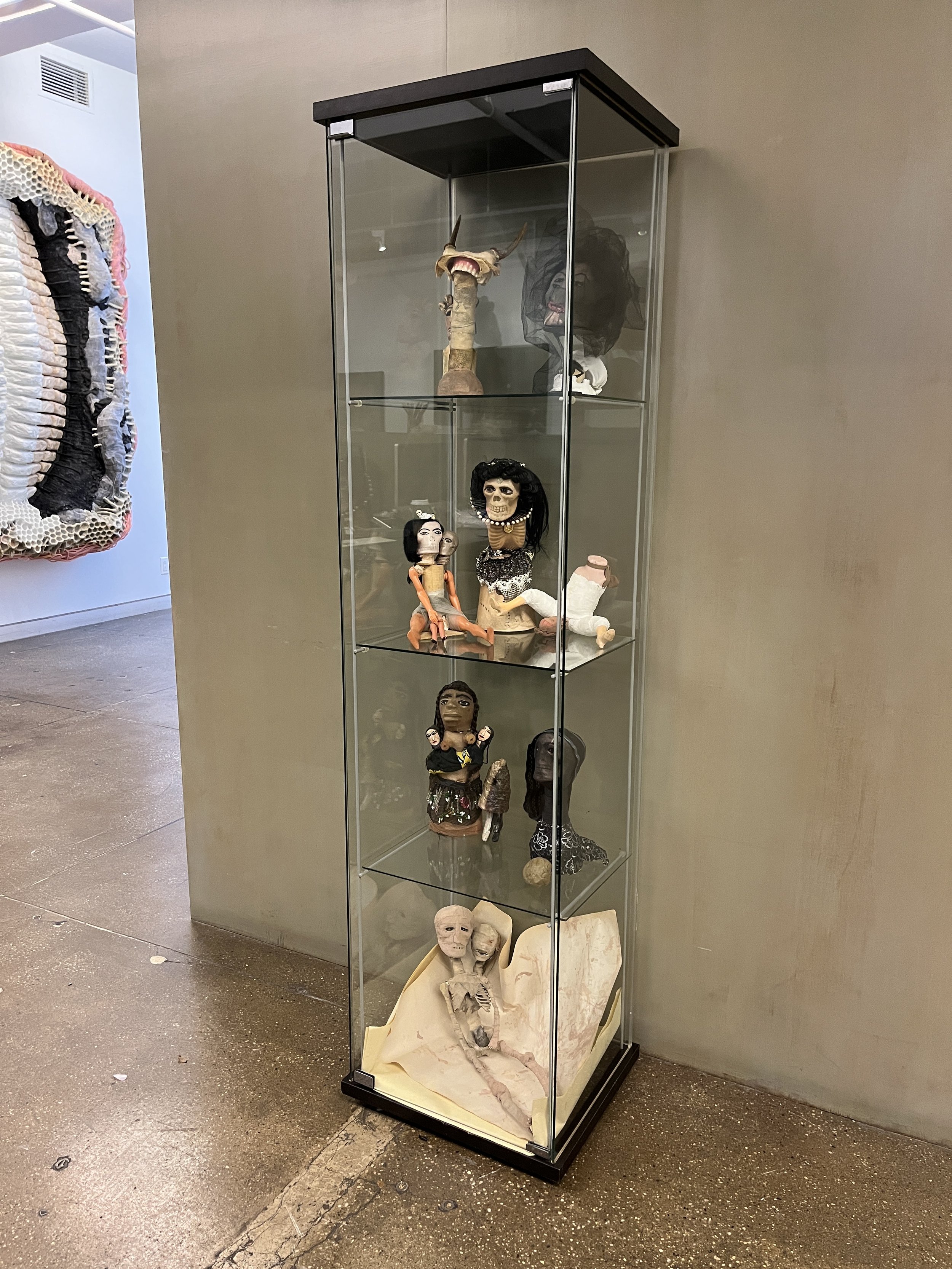   Samira Abbassy   A Confessional Autobiography Told in Archetypes through Effigies, Idols, Saints and Martyrs  2015-2022 Various materials Glass Cabinet: 63x14x15 inches 