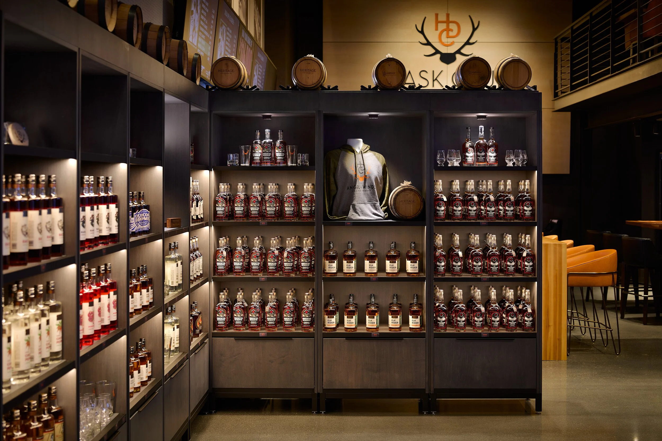 Tighter architectural detail image of the retail bottle display and merchandising shelving at Heritage Distilling tasting room, Angel of the Winds Casino Resort, designed by fi architecture.