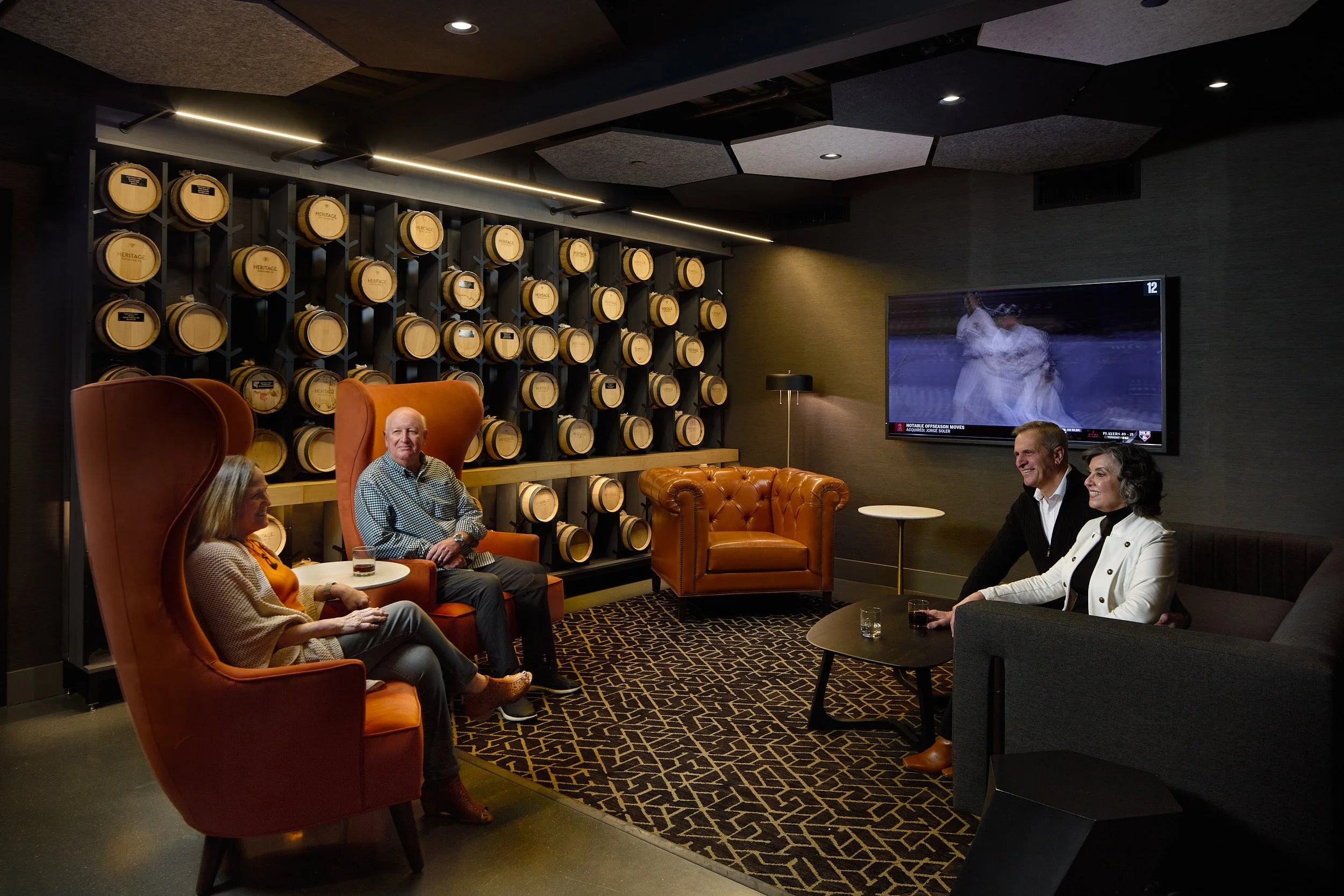 Interior architectural detail image showcasing patrons in the cozy, intimate seating area of Heritage Distilling tasting room, Angel of the Winds Casino Resort, designed by fi architecture.