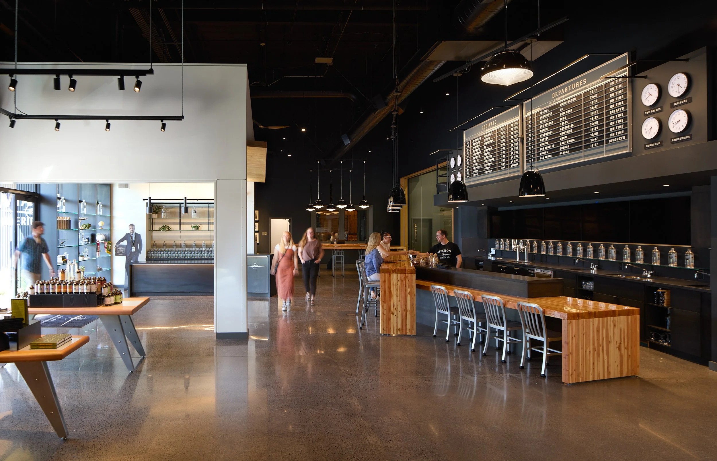 Grand interior architectural photography showcasing the tasting room and distillery production equipment at Aviation Gin Distillery in Portland, Oregon, designed by fi architecture.