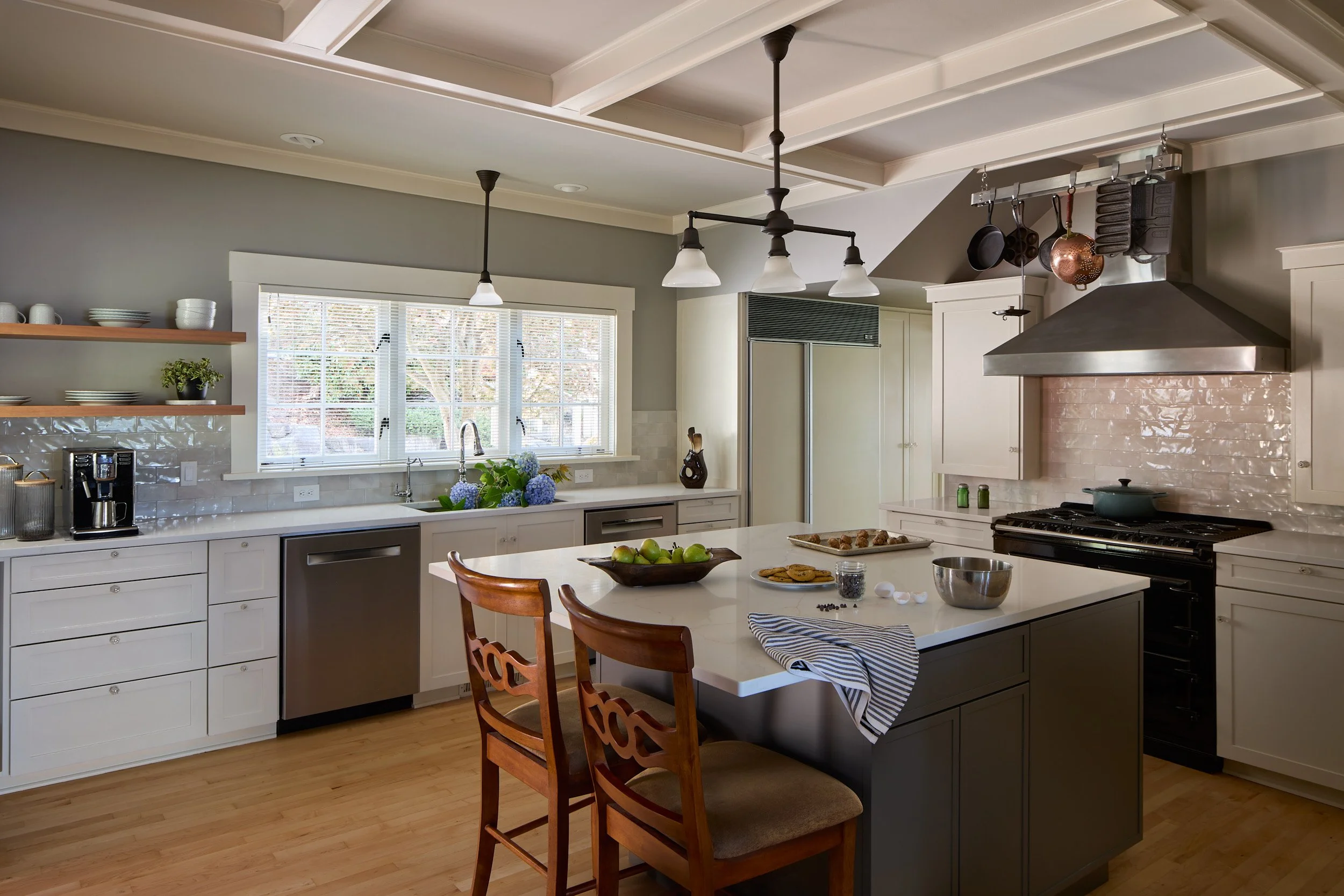 Kitchen interior featuring custom cabinetry, large island with seating, high-end appliances in this Olympia, WA residence by Brown Building Contractors.
