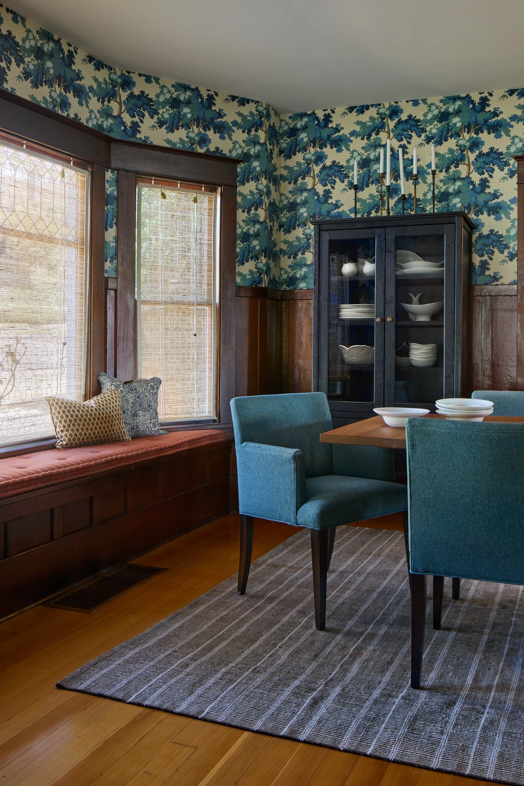 Front room and dining area interior shot of the Old Tacoma Residence, featuring a custom window seating nook, built-in shelving, and designed by Cupboard & Clay and Sonju Interior