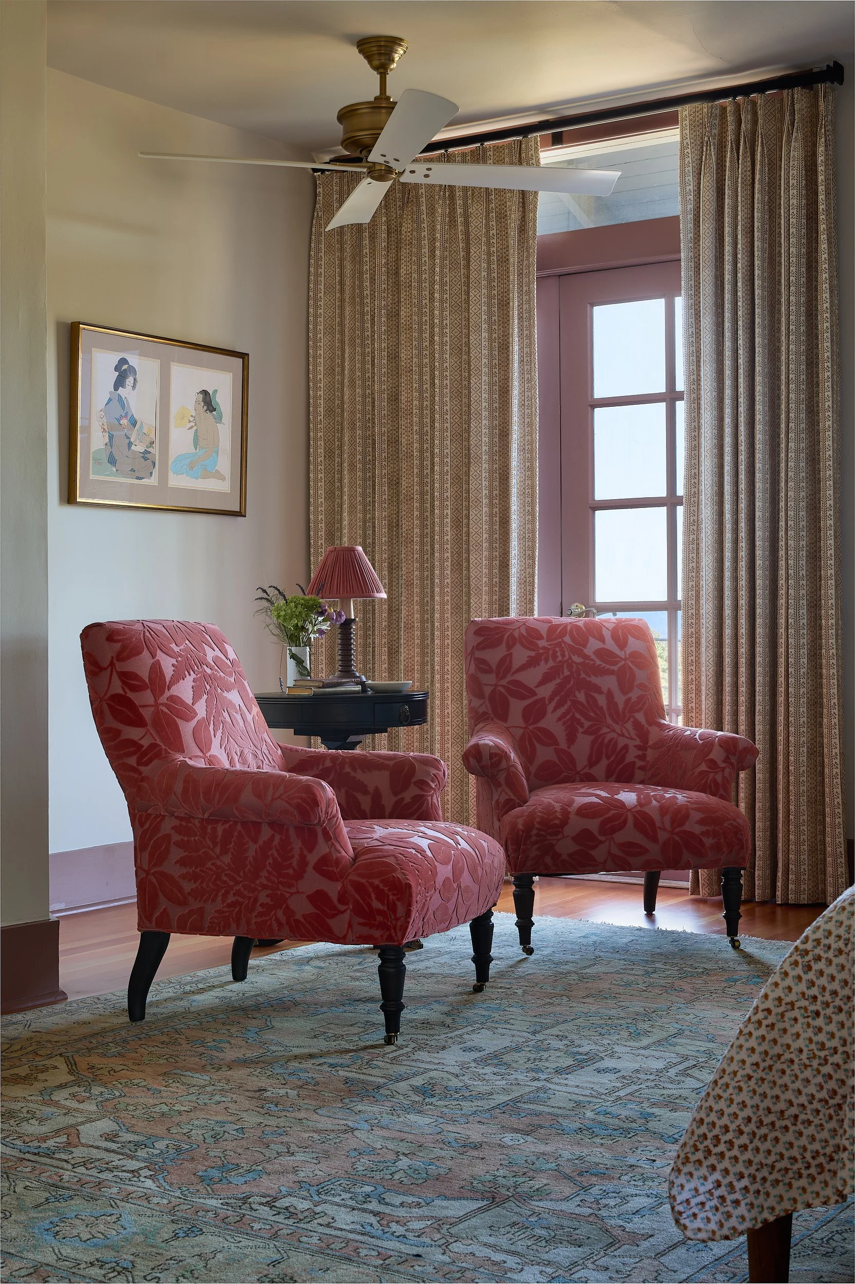 Vertical interior photo of an Old Tacoma Residence bedroom featuring a rich red jacquard fabric chair, custom carpet, matching window drapes, designed by Cupboard & Clay and Sonju Interiors