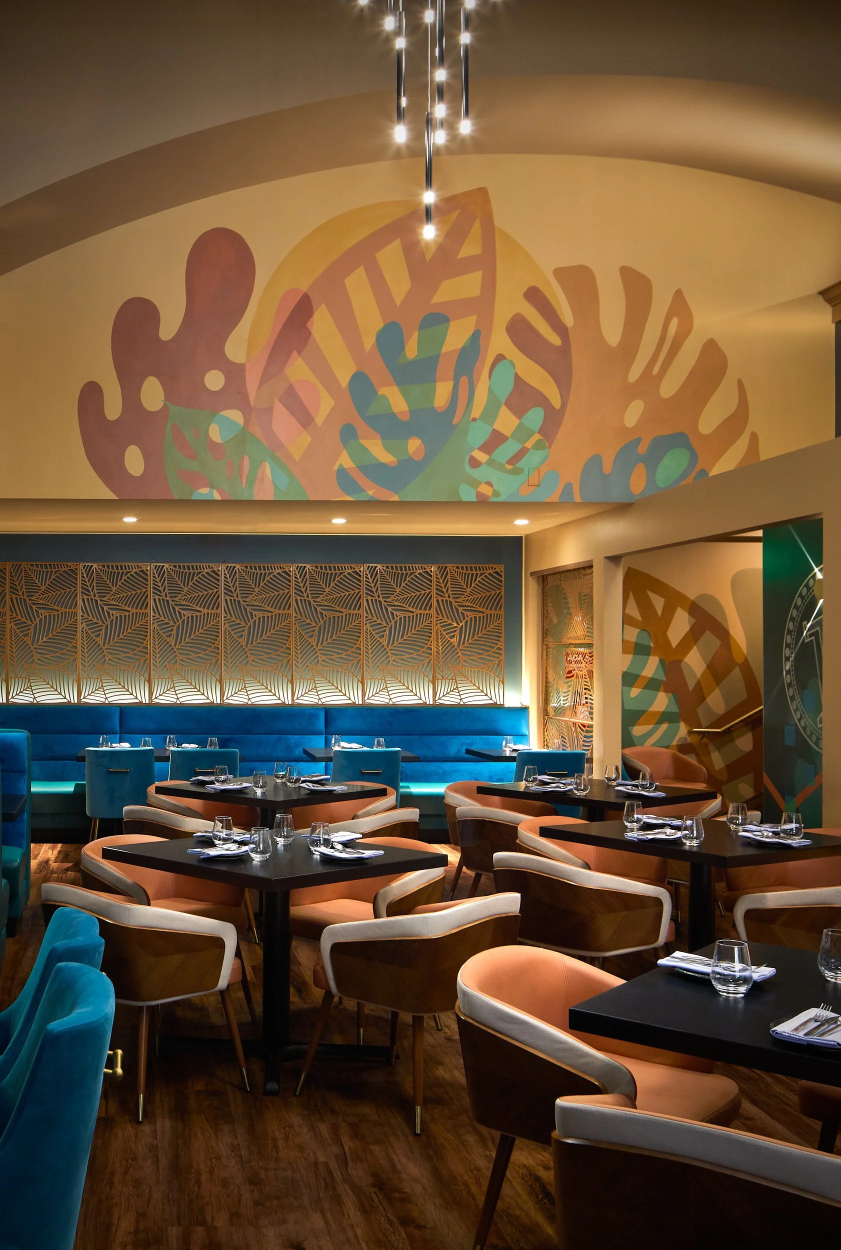 Vertical interior detail architectural image showcasing seating and contemporary art installation at Farzi Cafe, Bellevue, Washington, designed by Sue Genty Interior Design.