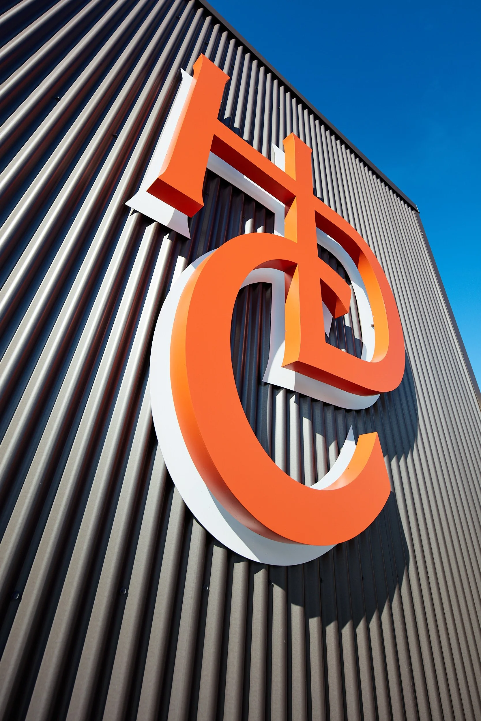 Vertical architectural detail image of the Talking Cedar Brewery and Distillery exterior signage in Grand Mound, Washington, designed by fi architecture.