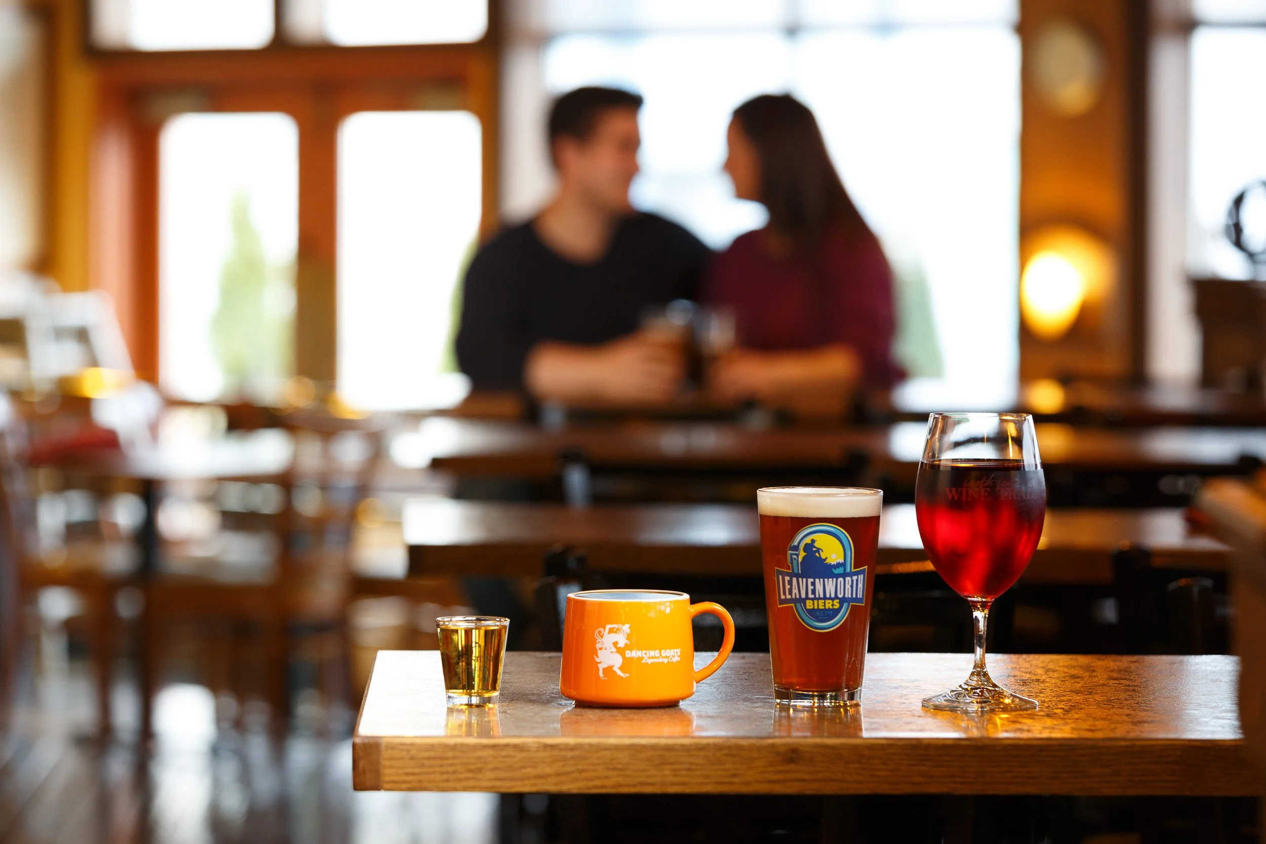 Candid lifestyle photograph of a couple sharing holiday beverages at Bud Bay Cafe in Olympia, Washington, promoted by Visit Olympia.