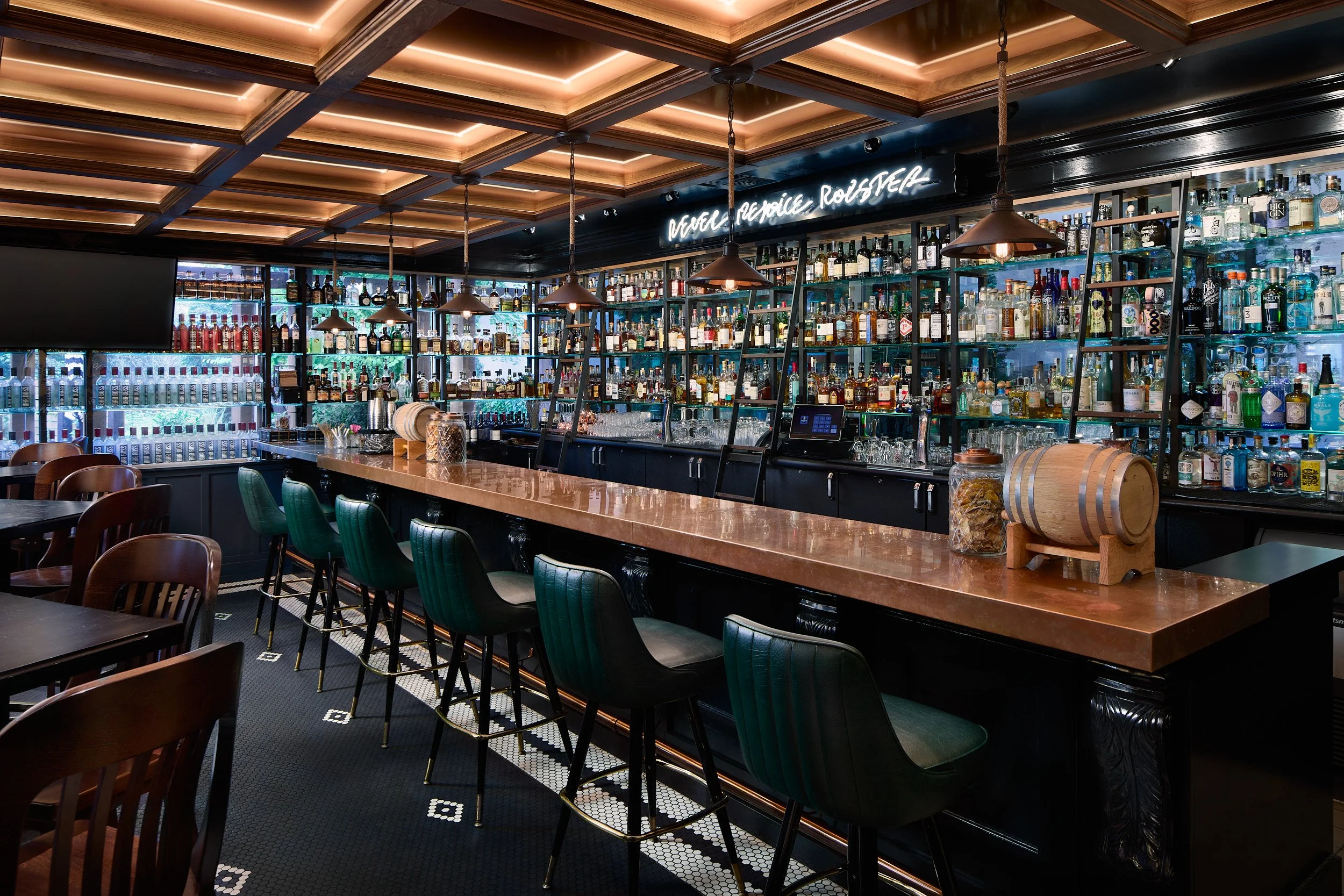 Interior architectural photography showcasing the fully stocked Vons 1000-Spirits bar and extensive liquor display wall in Woodinville, Washington, designed by Sue Genty Interior Design.