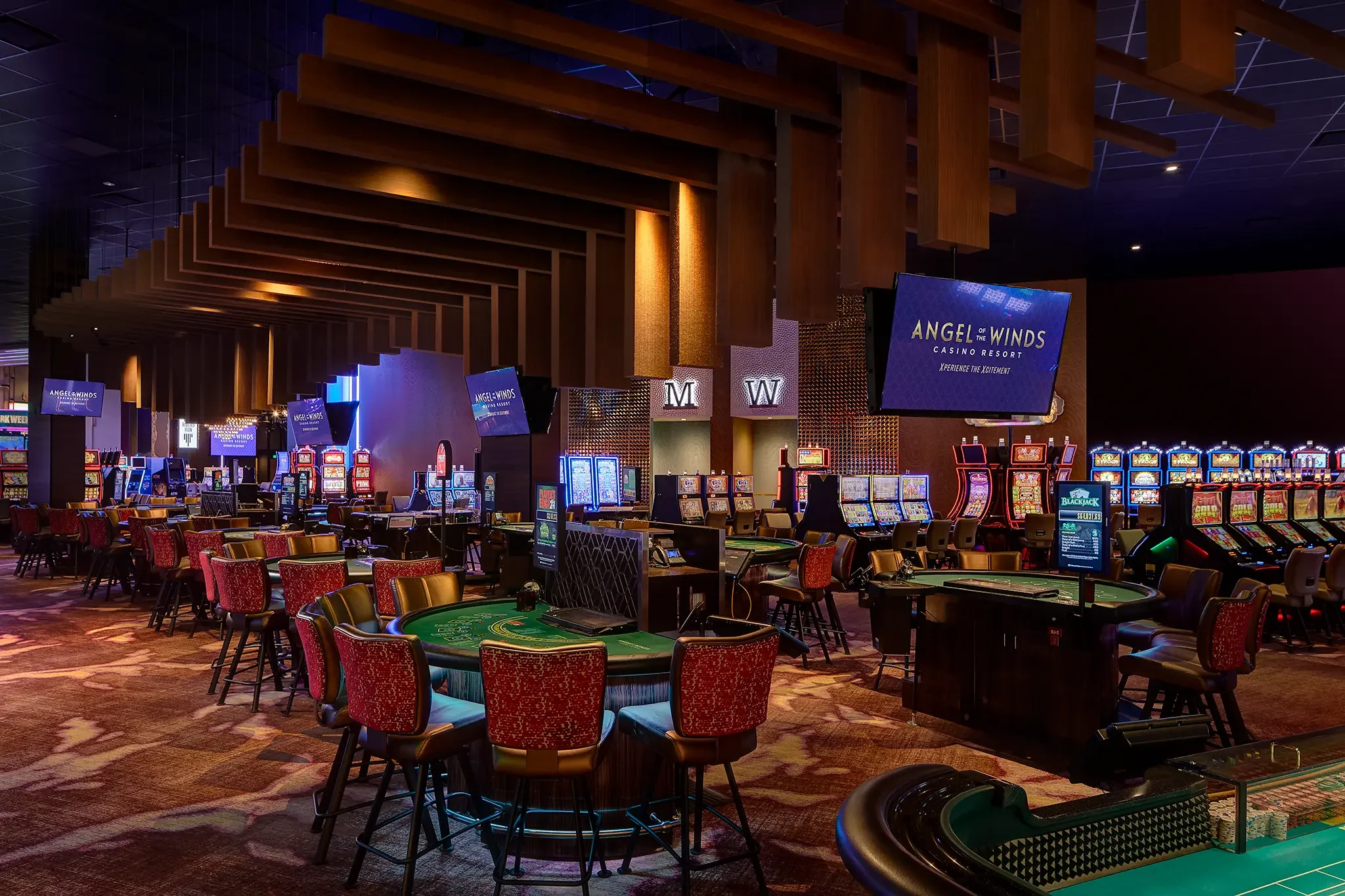 Casino interior featuring table games, bespoke lighting, and rich color palette at Angel of the Winds Casino, Arlington, WA., designed by Cuningham Architects.