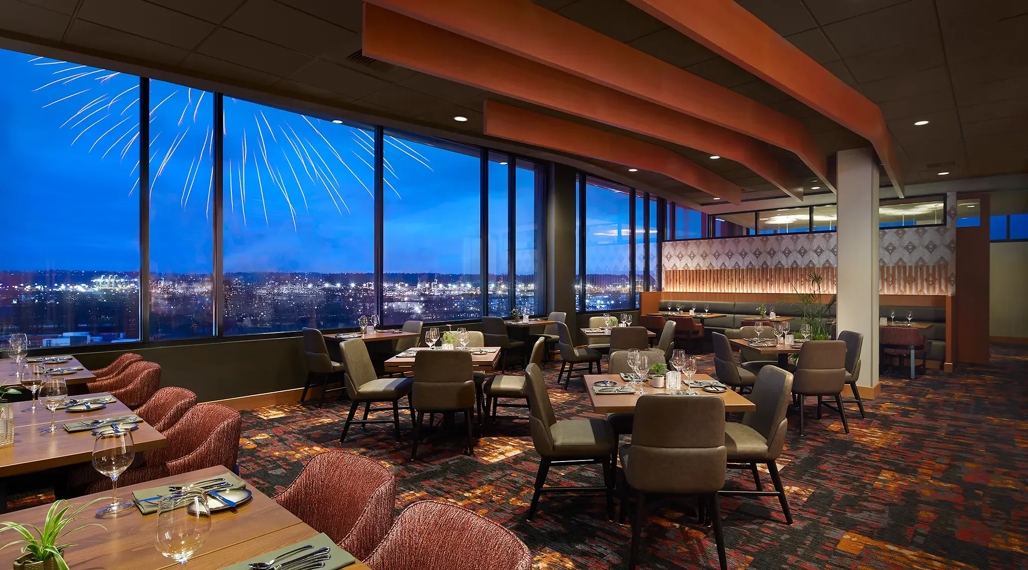 Elegant fine dining at dusk at Slahal Steakhouse, featuring city views at the Emerald Queen Casino Hotel in Tacoma, WA, by Cuningham Architects.