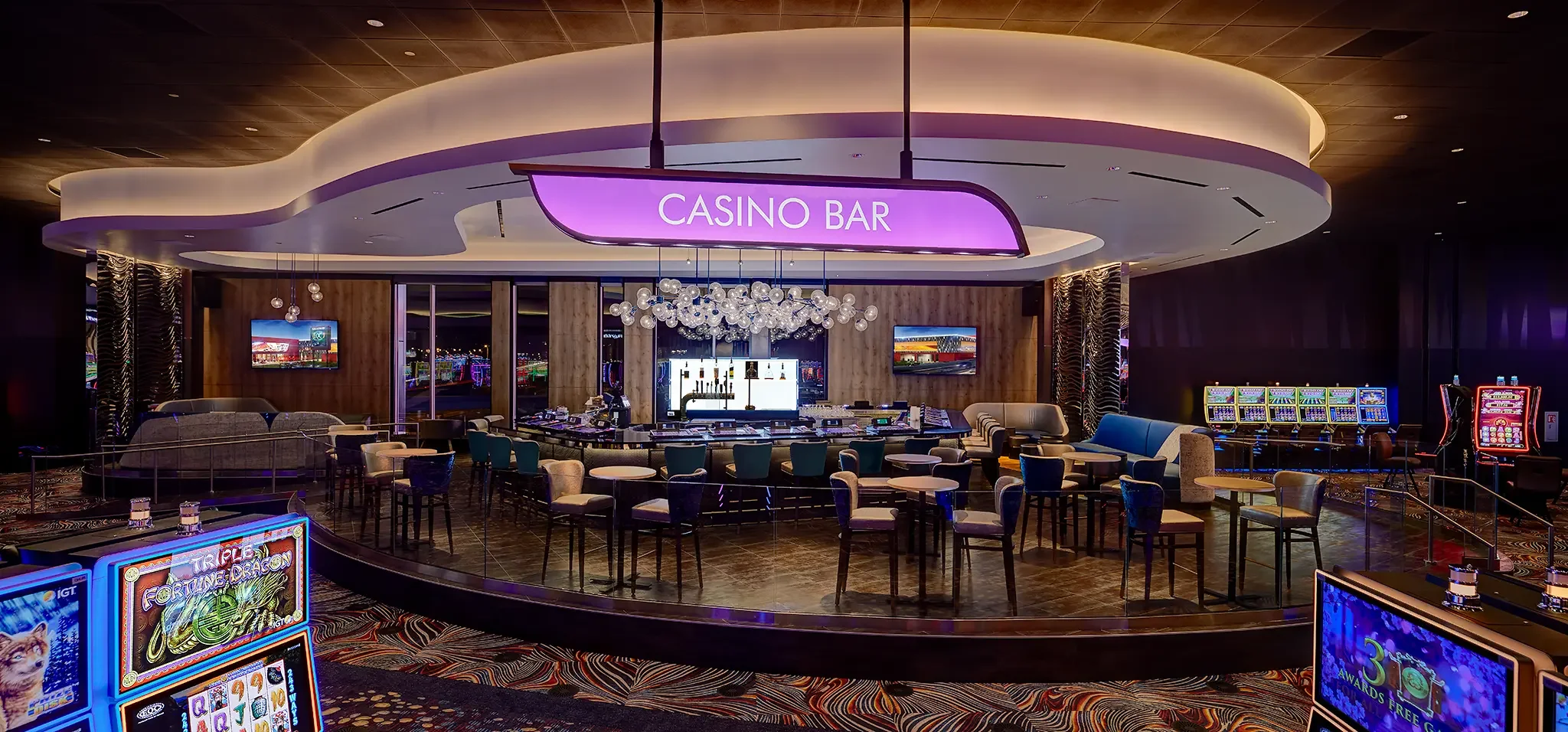 Center Casino Bar architectural design featuring striking backlit signage and custom detailing inside the main floor of the Emerald Queen Casino (EQC) project by Cuningham Architects.