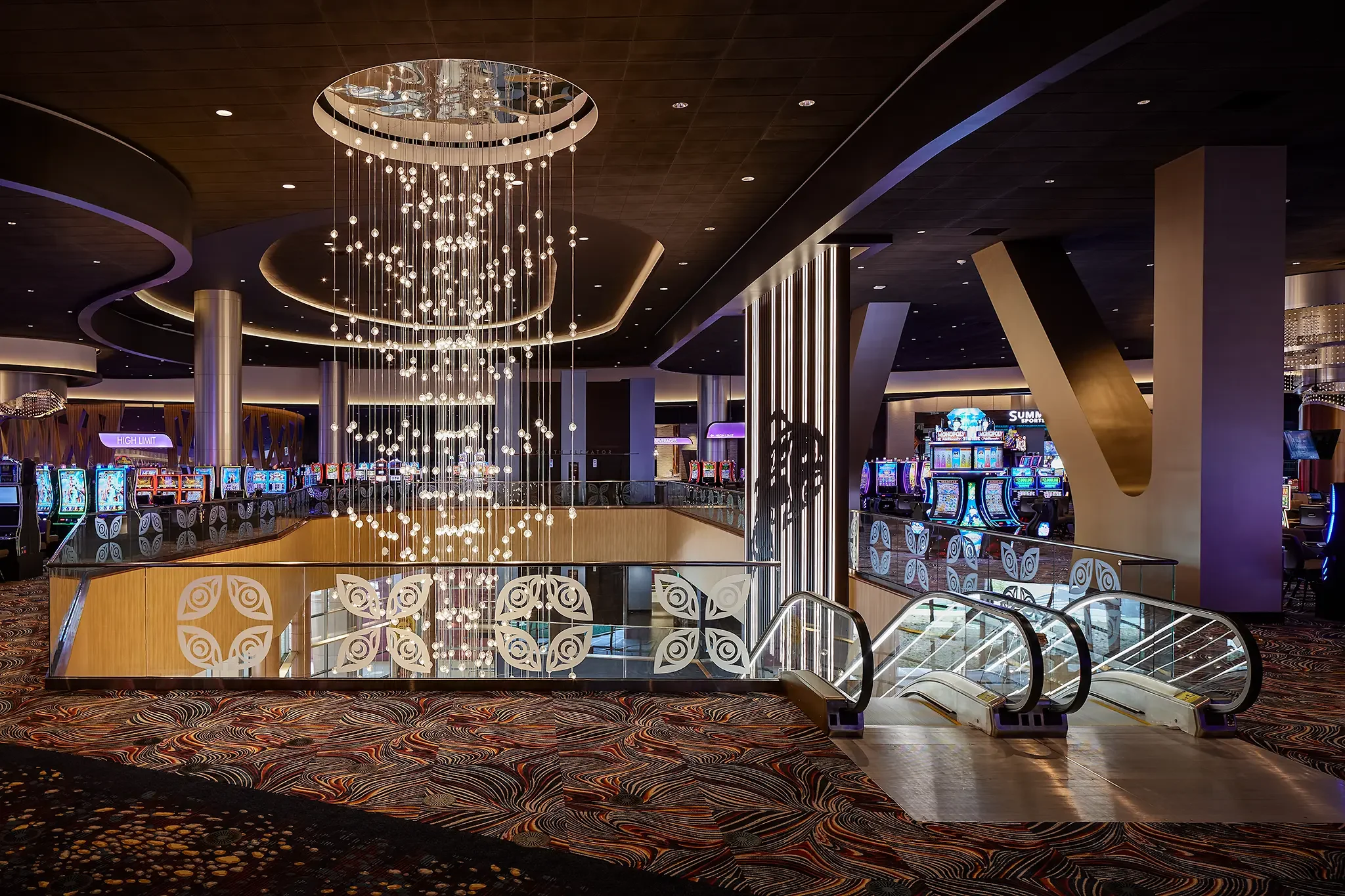 Escalator landing area and architectural detail just inside the entrance of the Emerald Queen Casino, featuring integrated Native artwork display, designed by Cuningham Architects.