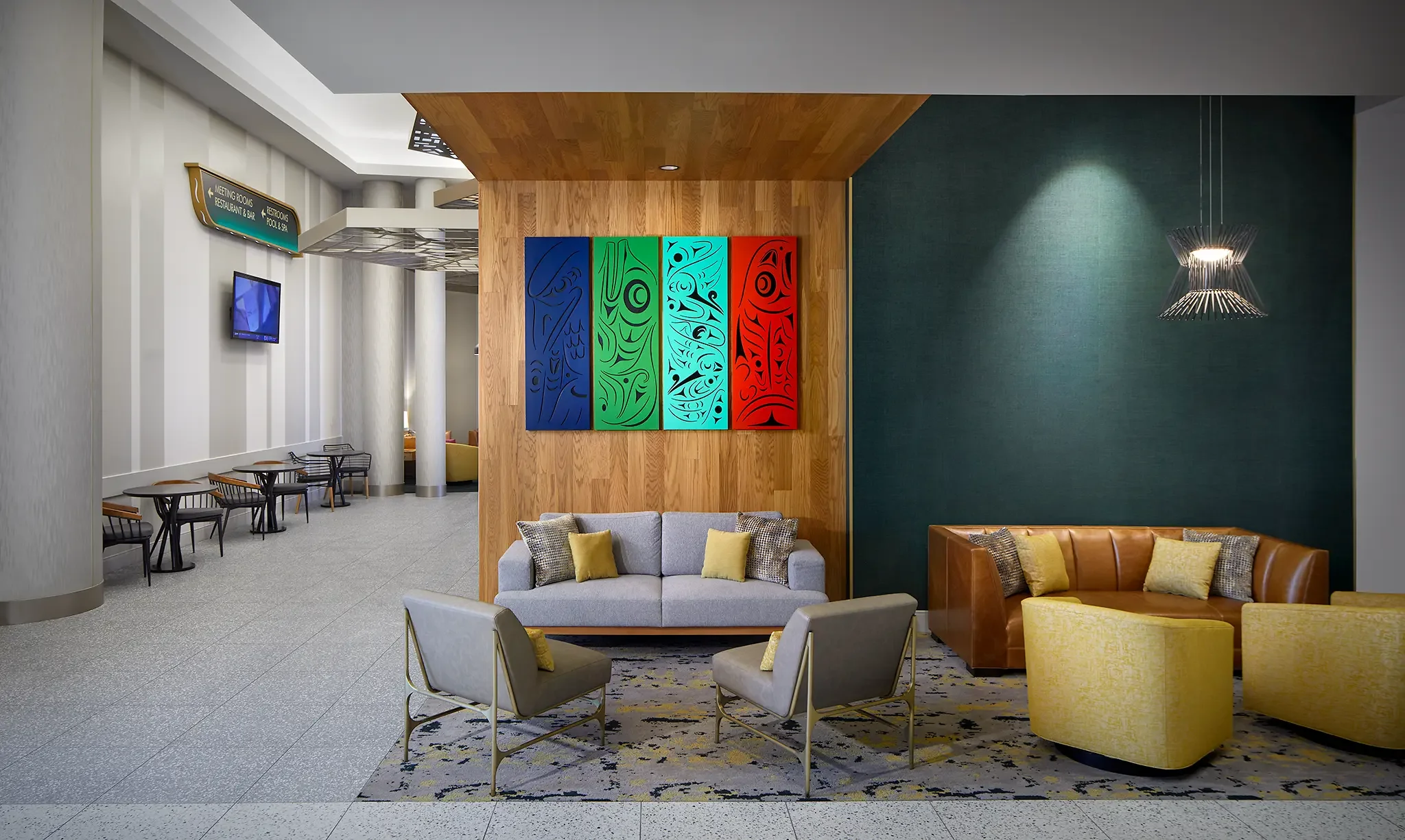 Architectural photograph of the hotel's public area, showing a contemporary seating lounge featuring prominently displayed Native artwork just past the Emerald Queen Casino Hotel lobby.
