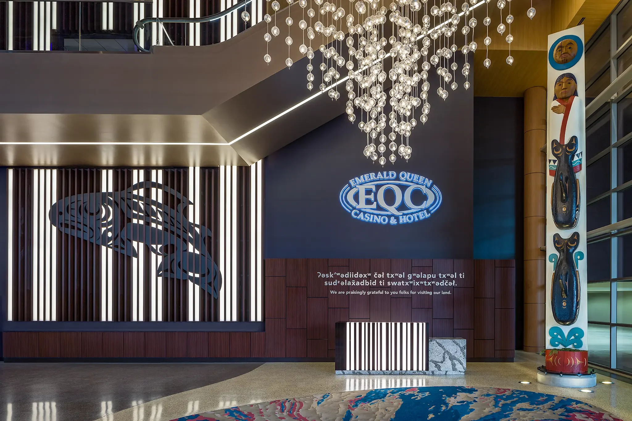 Valet desk and counter detail featuring custom design, Native artwork, and cultural writing elements inside the Emerald Queen Casino project by Cuningham Architects.