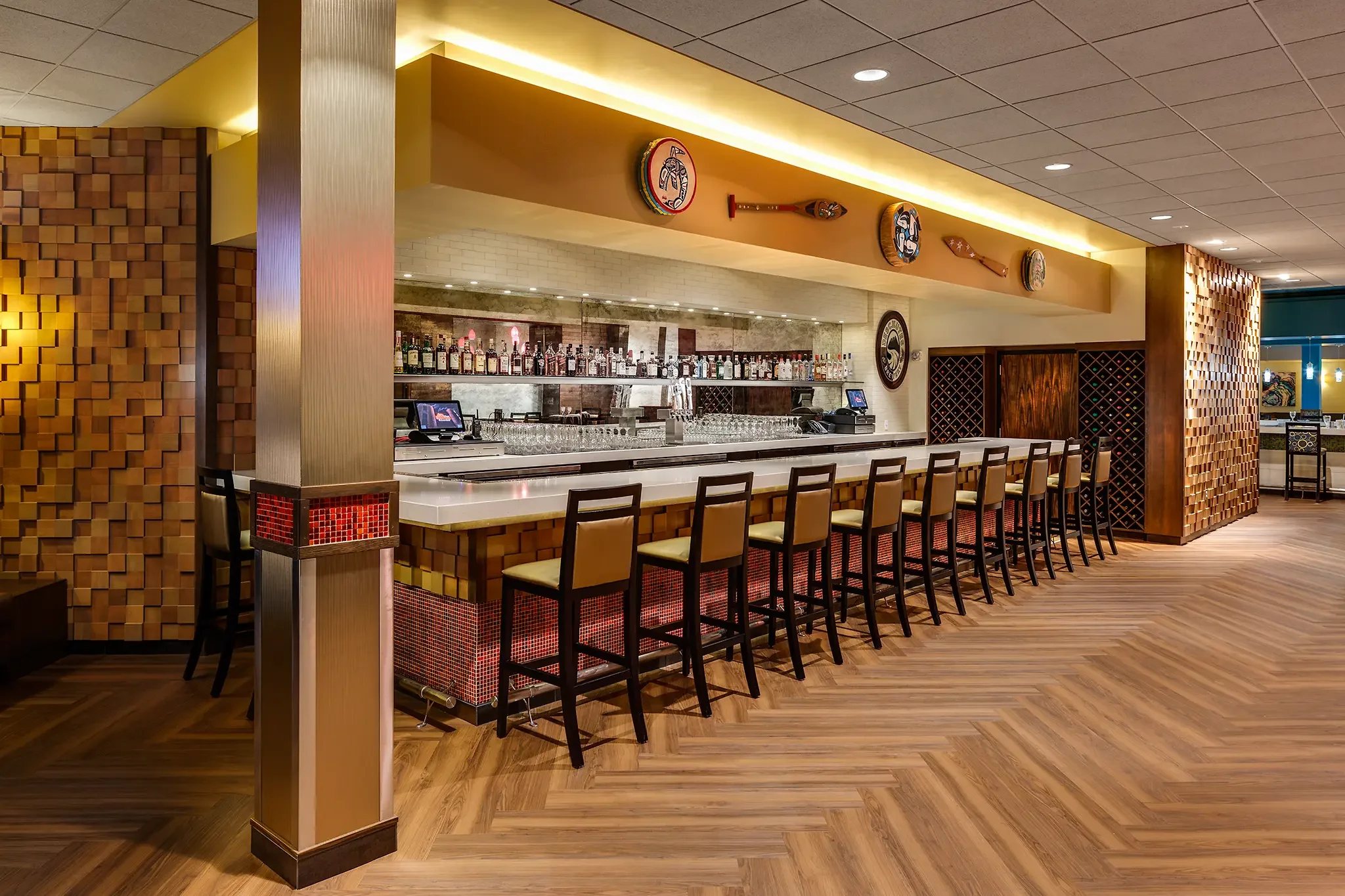 Beautiful backlit bar with native artwork inside the non-smoking casino at the Nisqually Red Wind Casino, Olympia, WA, interior design by KMB Architects.