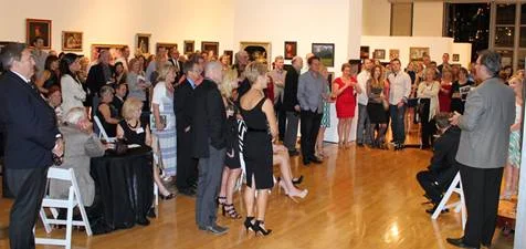 a crowd of people inside a gallery