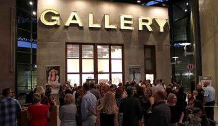a crowd of people outside a gallery