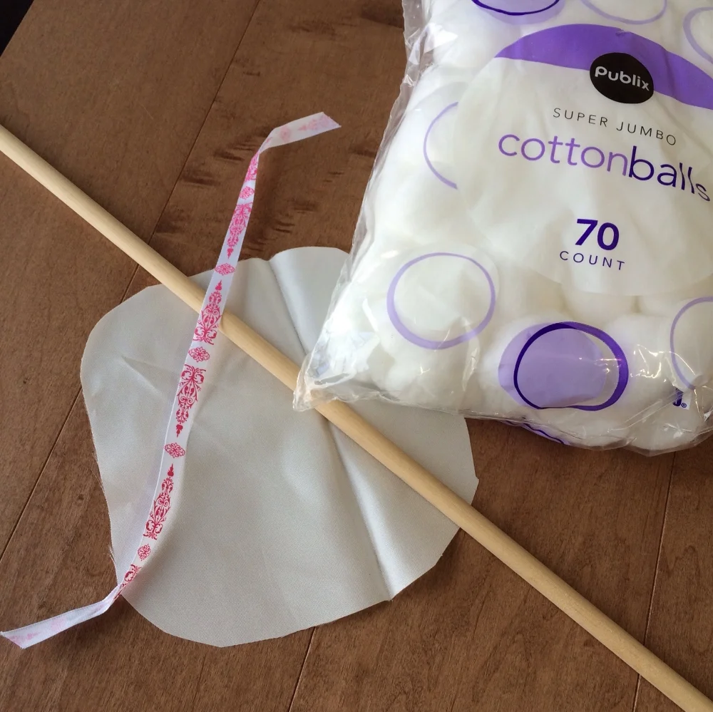 a dowel stick, cotton balls, silk and a ribbon