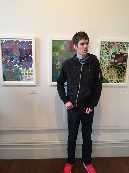 Matthew Allerby at the "Good Shapes" Exhibition Opening with some of his artwork