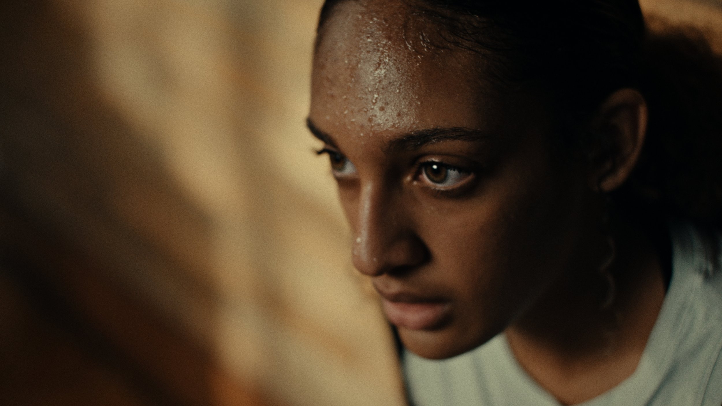 Close-up of a person with sweat on their face, looking focused.