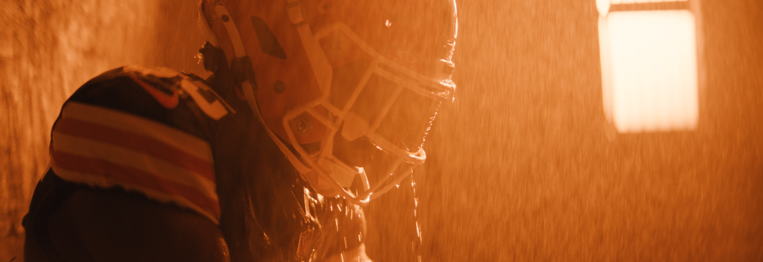 American football player in helmet, wet from rain.  Cleveland Browns. Sports director of photography camera operator. Arri Alexa 35 anamorphics.