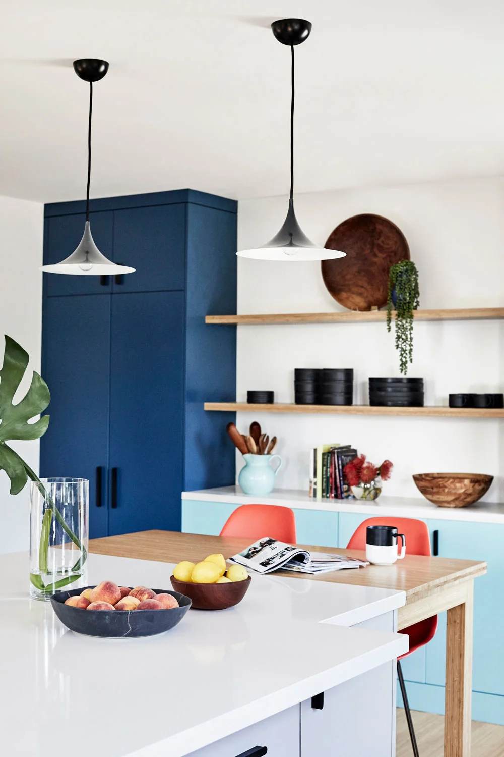 Adding a counter-height bamboo kitchen table to the end of the island makes dinner for the kids so easy. And, those pendant lights makes it feel cozy.