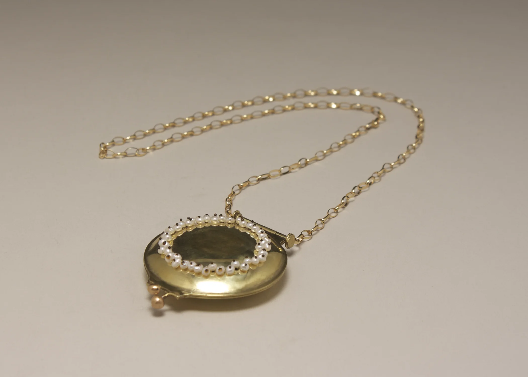 Compact Locket {closed}. brass. sterling silver. gold fill chain. pearls. plastic. photograph.