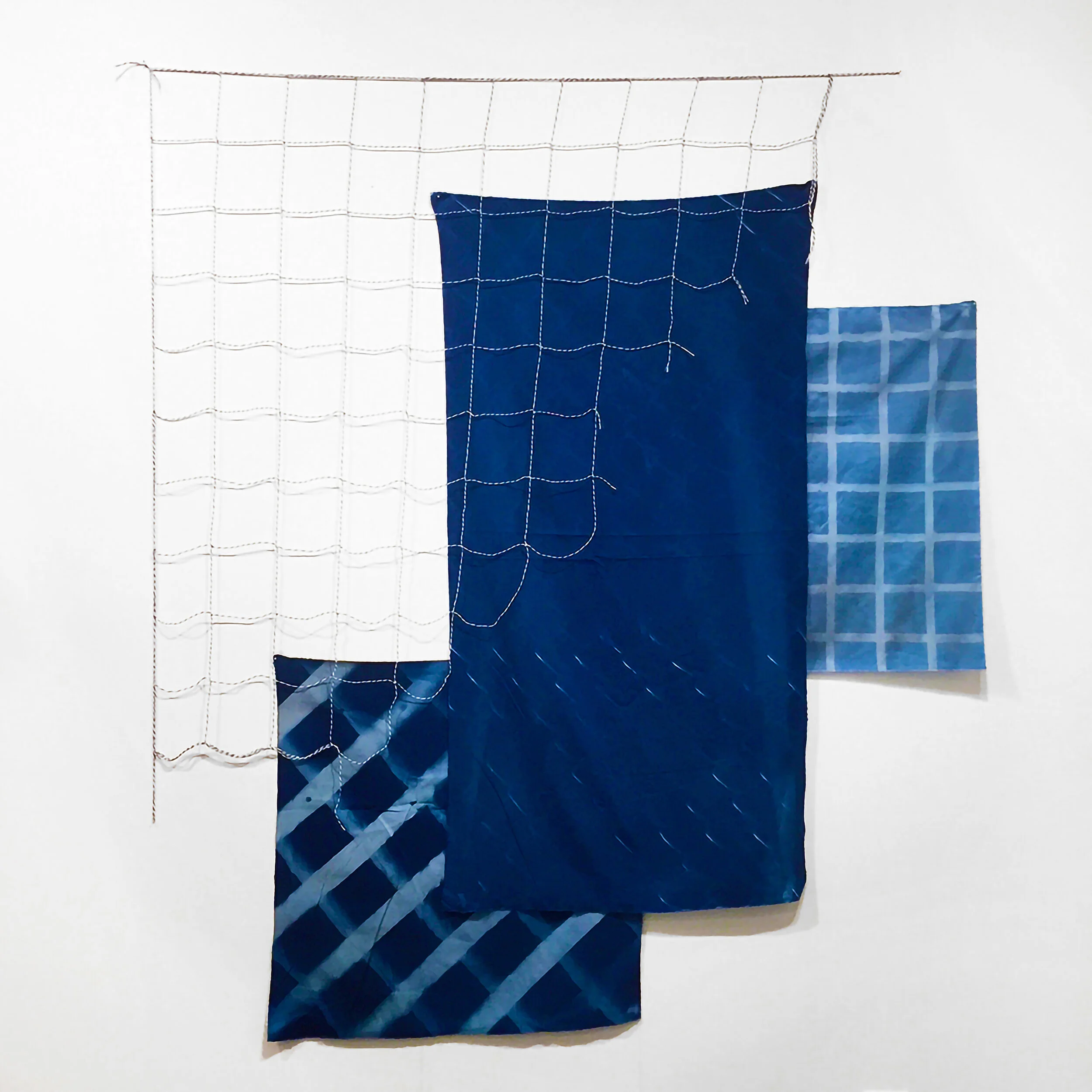 untitled (assemblage 001). 2018. cyanotype on found fabric, bakers twine, and nails. 57 x 53 x 1/2 inches